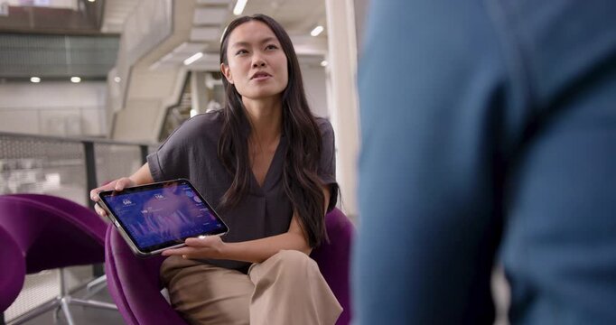 Business Meeting with Colleagues  in Open Plan Modern Office, using Digital tablet