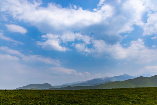 Vast Mountain Landscape with Rolling Green Hills and Cloudy Sky