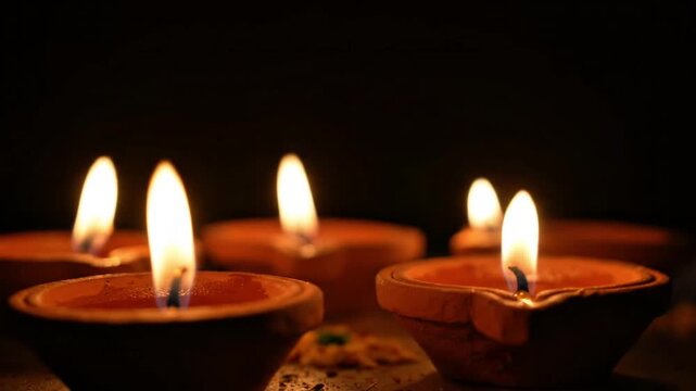 Traditional Clay Diya Lamps Burning with Warm Flame on Dark Background Diwali Celebration