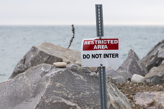 Restricted Area Do Not Enter Warning Sign on Rocky Shoreline