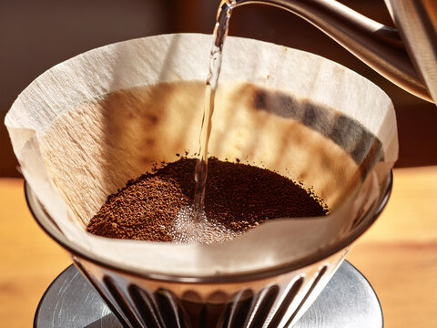  freshly ground coffee being poured into a coffee filter