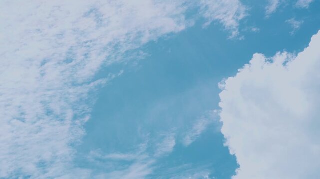 Fluffy white clouds and bright blue sky on a sunny day, concept of weather, natural environment, freedom, peace, and atmosphere for background and design use.