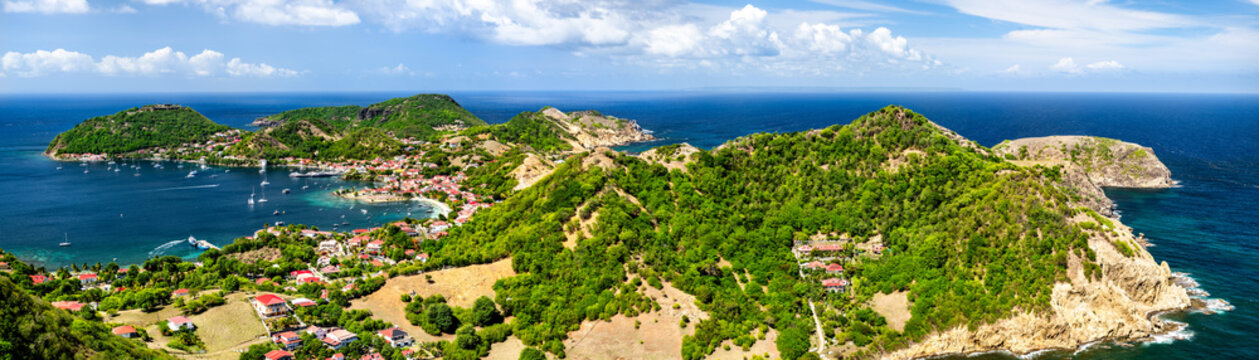Panoramic aerial view of Terre-de-Haut island, its bay, and lush green hills in Les Saintes, Guadeloupe, Caribbean.