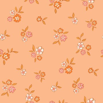 Seamless ditsy floral pattern with small colorful flower bouquets on peach background