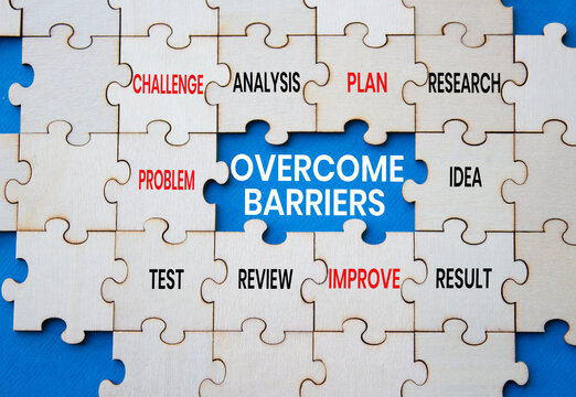 Overcome barriers symbol. Concept words overcome barriers on wooden puzzle pieces over blue background. Idea puzzle piece. Problem solving concept. Copy space.