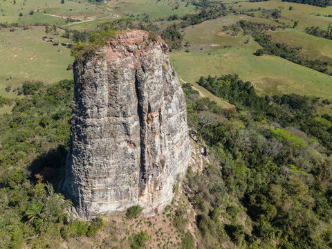 Aerial view of Torre de Pedra rock formation surrounded by green hills