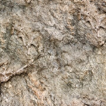 Close-up texture of rough natural rock formation, cliff side or rugged granite stone surface background.