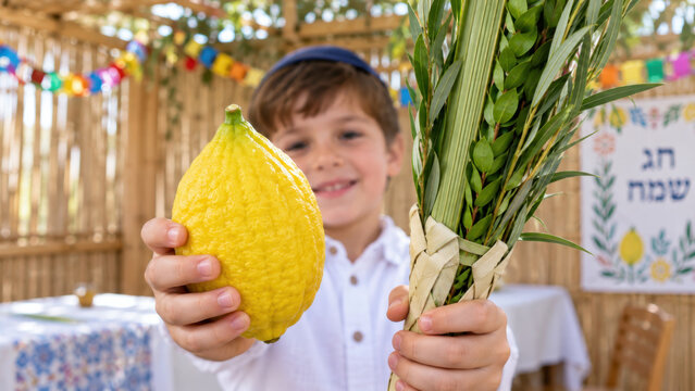 Large citron held toward camera by boy, child offering etrog beside bound lulav in a festive sukkah, festival promotion banner for seasonal faith gathering