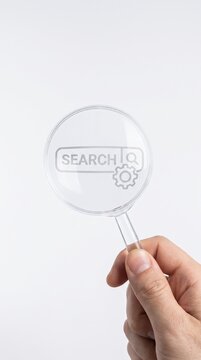 Hand holding magnifying glass isolated on white background