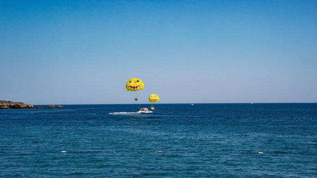 Brightly colored parasailing adventure on a sunny day over the shimmering blue ocean.