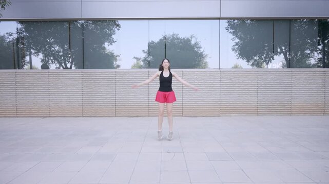 Athletic woman exercising with jumping jacks outside