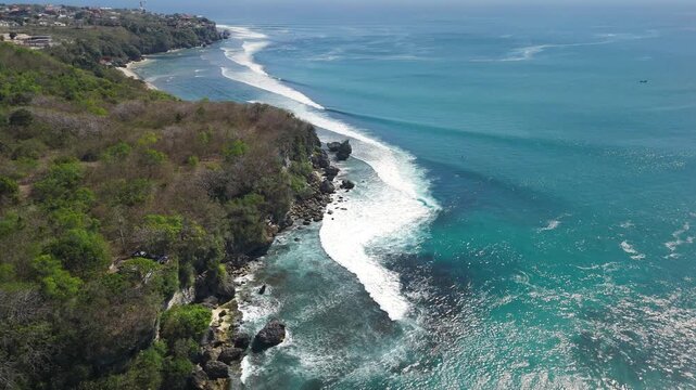 Above view with crashing surfing waves in ocean on Padang Padang beach