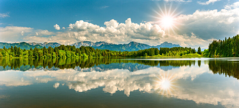 Im Allg&auml;u spiegeln sich die Berge auf der Wasseroberfl&auml;che des Schmutterweiher bei Ro&szlig;haupten - FOTOMONTAGE