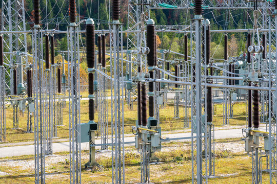 Am Wasserkraftwerk an der Isar bei Kr&uuml;n steht ein elektrisches Umspannwerk mit Transformatoren, Isolatoren und Stromleitungen.