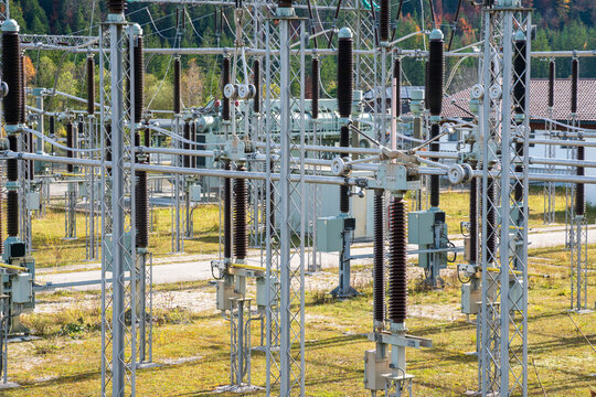 Am Wasserkraftwerk an der Isar bei Kr&uuml;n steht ein elektrisches Umspannwerk mit Transformatoren, Isolatoren und Stromleitungen.