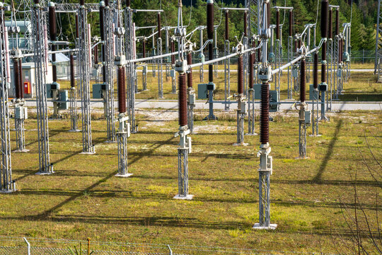 Am Wasserkraftwerk an der Isar bei Kr&uuml;n steht ein elektrisches Umspannwerk mit Transformatoren, Isolatoren und Stromleitungen.