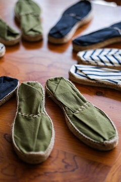 Collection d espadrilles artisanales en toile disposees en cercle sur une table en bois