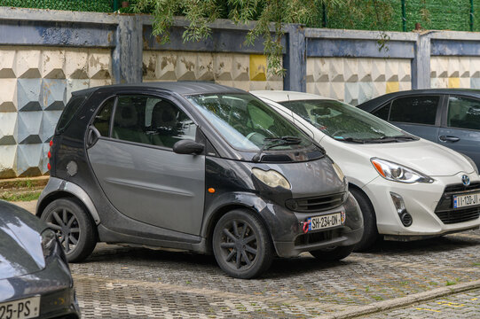 August 15, 2026, Tbilisi, Georgia Commercial automotive stock photography of a parked grey Smart car and adjacent vehicles in an urban lot