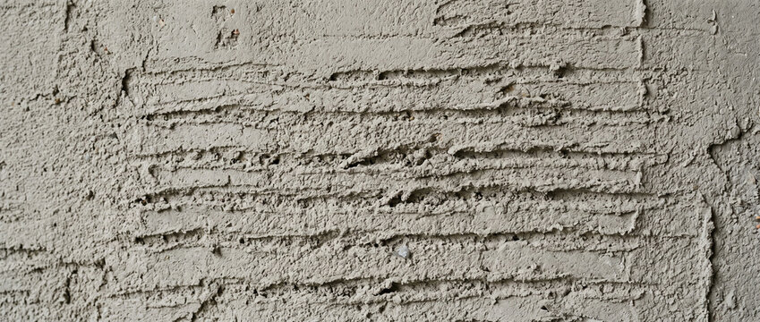 Textured gray wall with horizontal lines and rough surface  