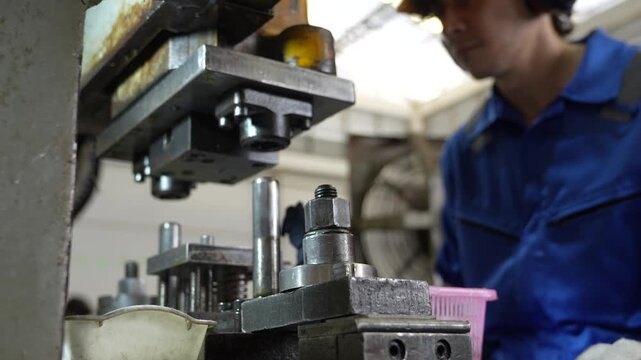 Industrial machine factory worker operating metal stamping equipment production workshop, focused manufacturing process with metal fixture, steel mechanical machinery, machine tool engineering