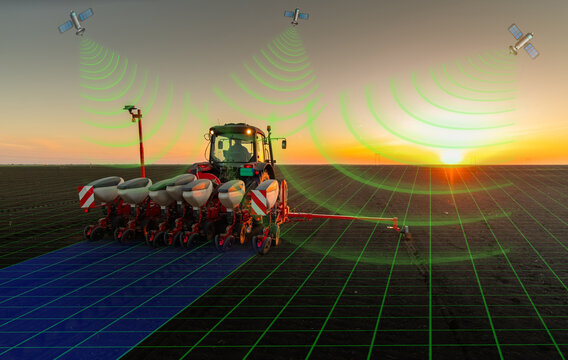 Farmer with tractor seeding in sunset