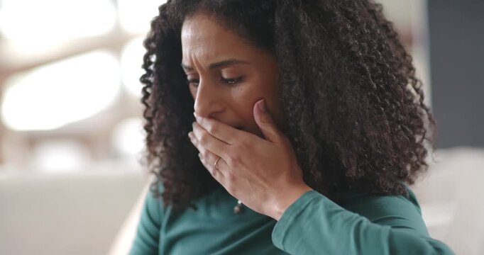 African American woman reacting to alert, covering mouth, checking smartphone in living room