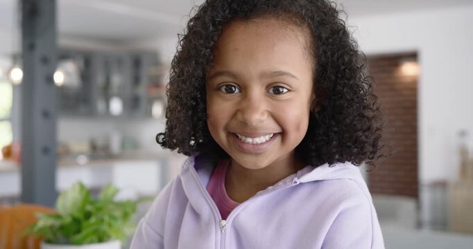 African American schoolchild smiling for portrait as camera pulling back showing plant and pumpkin