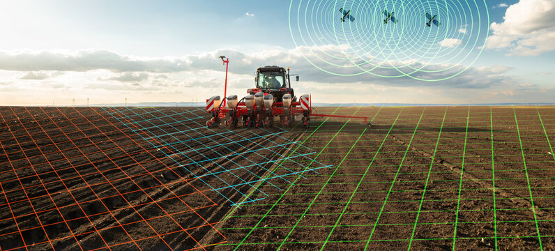 Modern tractor planting corn with precision seeder on agricultural field