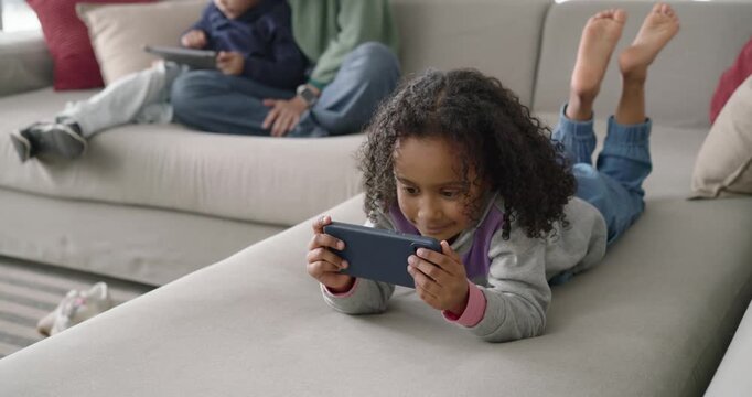 African American female family reacting to ping, youth smiling on couch while mother guiding tablet