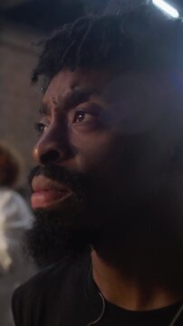 Young African American man listening attentively during live meeting with serious expression and subtle nod of agreement showing focus affirmation and thoughtful engagement