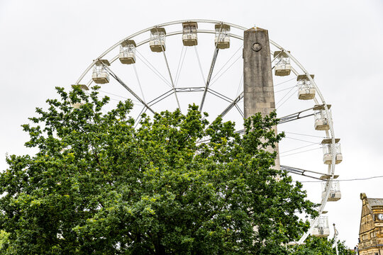 Ferris wheel behind tree in Harrogate, UK.
