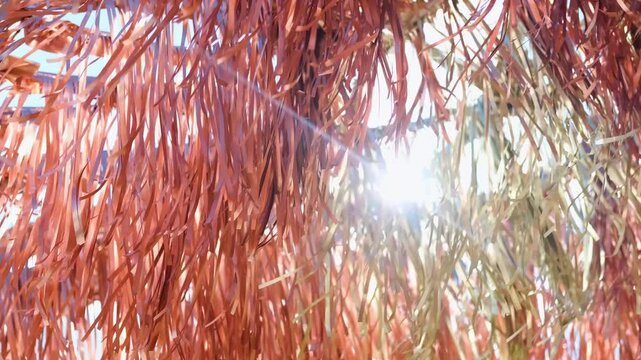 Close-up of metallic copper and gold colored decorative tinsel fluttering in the wind outdoors