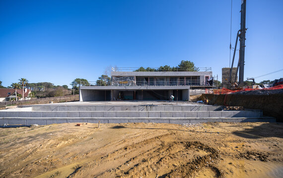 Modern stone house construction site with retaining wall