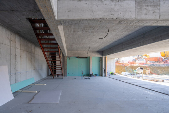 Concrete interior with metal staircase under construction