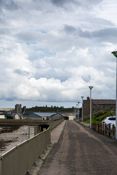 Coastal Pathway with Buildings and Cloudy Sky in Thurso, Scotland, UK.
