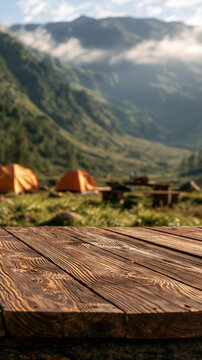A rustic wooden tabletop with a scenic mountain camping background featuring tents and morning mist. Great for food and product display concepts in outdoor adventures.