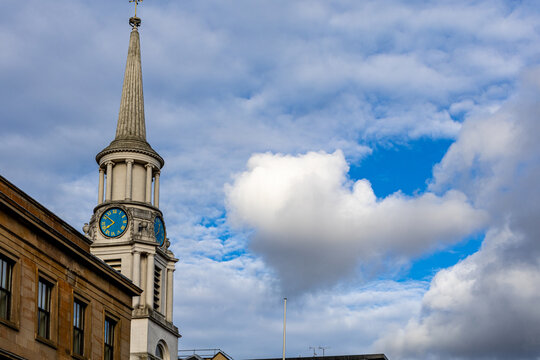 Church Steeple with Clock Against Cloudy Sky in Glasgow, Scotland, UK.
