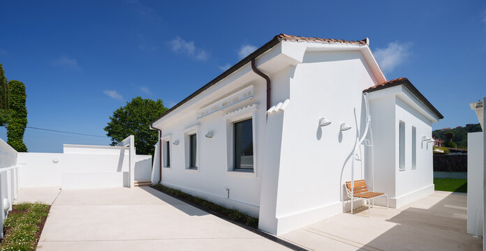 White modern house with courtyard garden under blue sky
