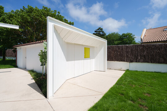 Modern white garden pavilion with yellow window accent