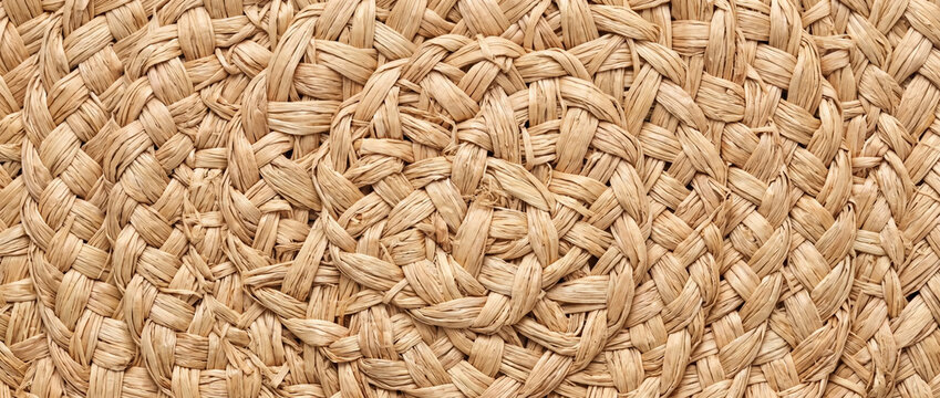 Natural raffia fiber woven texture background. Circular straw mat pattern
