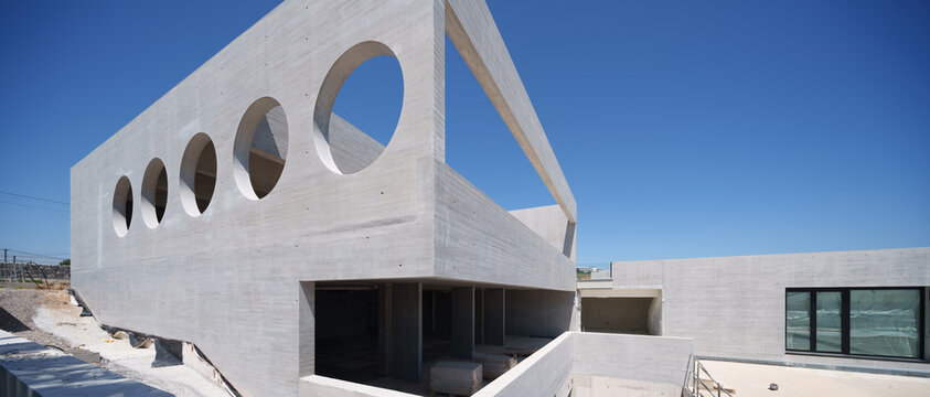 Modern concrete hotel under construction with circular windows