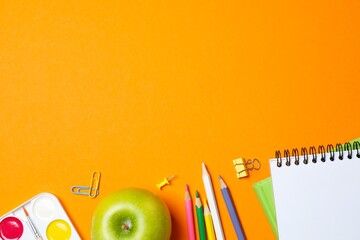 Back to school composition with vibrant stationery on orange background. Space for text © Sunlight