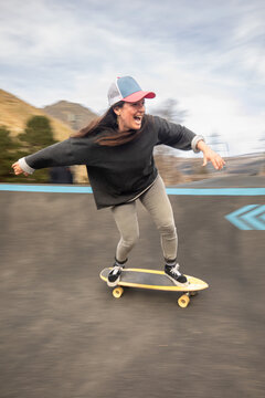 Happy woman skateboarder ride at an outdoor pump track