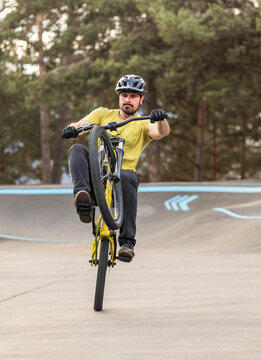 Male cyclist perform wheelie at outdoor pump track