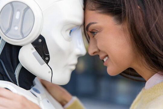 Extreme close-up of smiling woman looking into eyes of robot