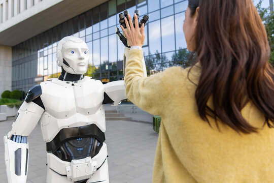 Humanoid robot giving high five to young woman