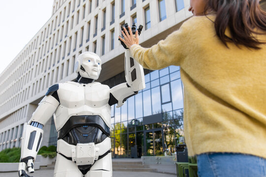 Android robot making high five gesture with smiling woman