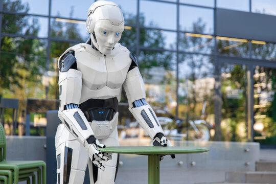 Humanoid android adjusting green table on terrace