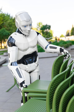 Close-up modern robot working with terrace furniture