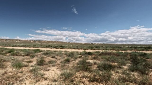 Camera moving forward along a dirt track in an arid landscape